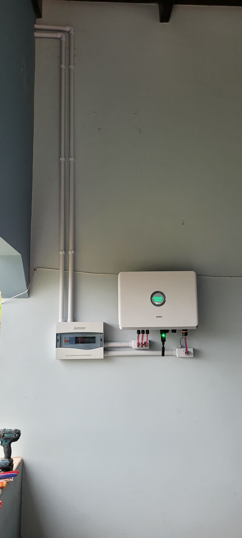 Inversor e medidor instalados em parede clara, com eletroduto aparente alinhado