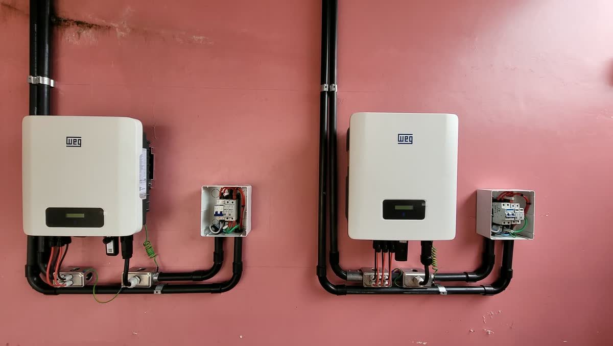 Dois inversores WEG instalados em parede externa, com curvas de eletroduto simétricas