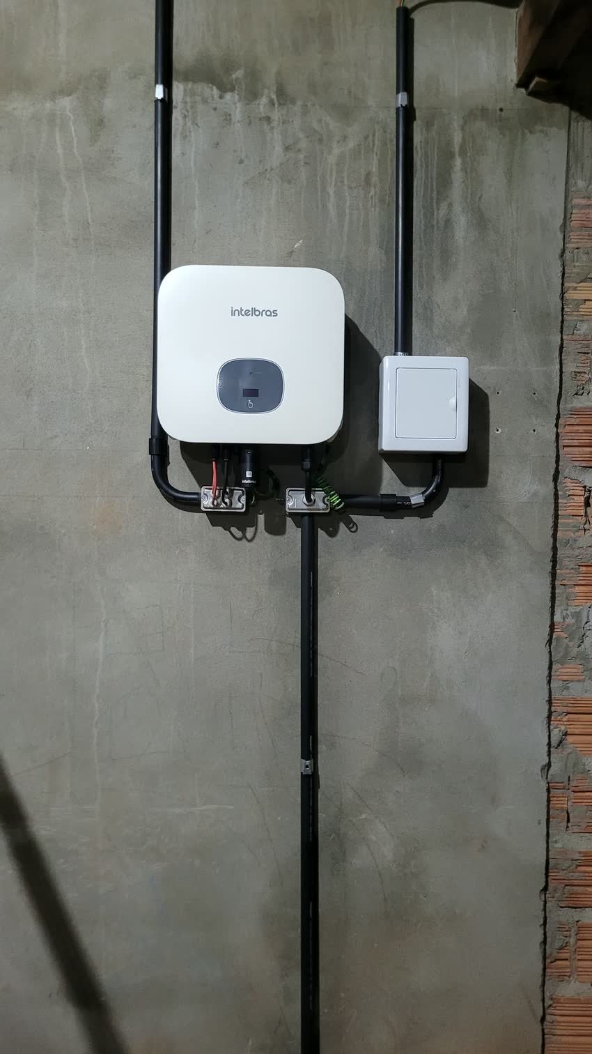 Inversor e caixa de derivação instalados em pilar de concreto