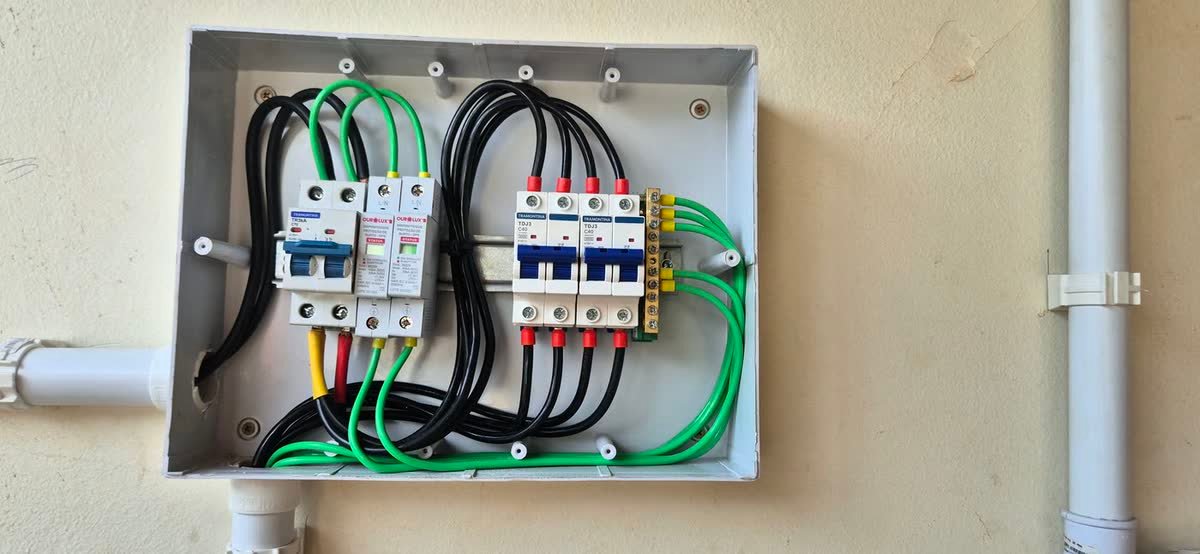 Quadro de proteção aberto com disjuntores e cabeamento acabado